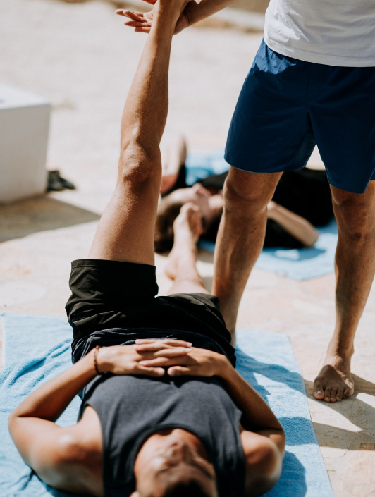 Een kinesist helpt een man om zijn been te stretchen